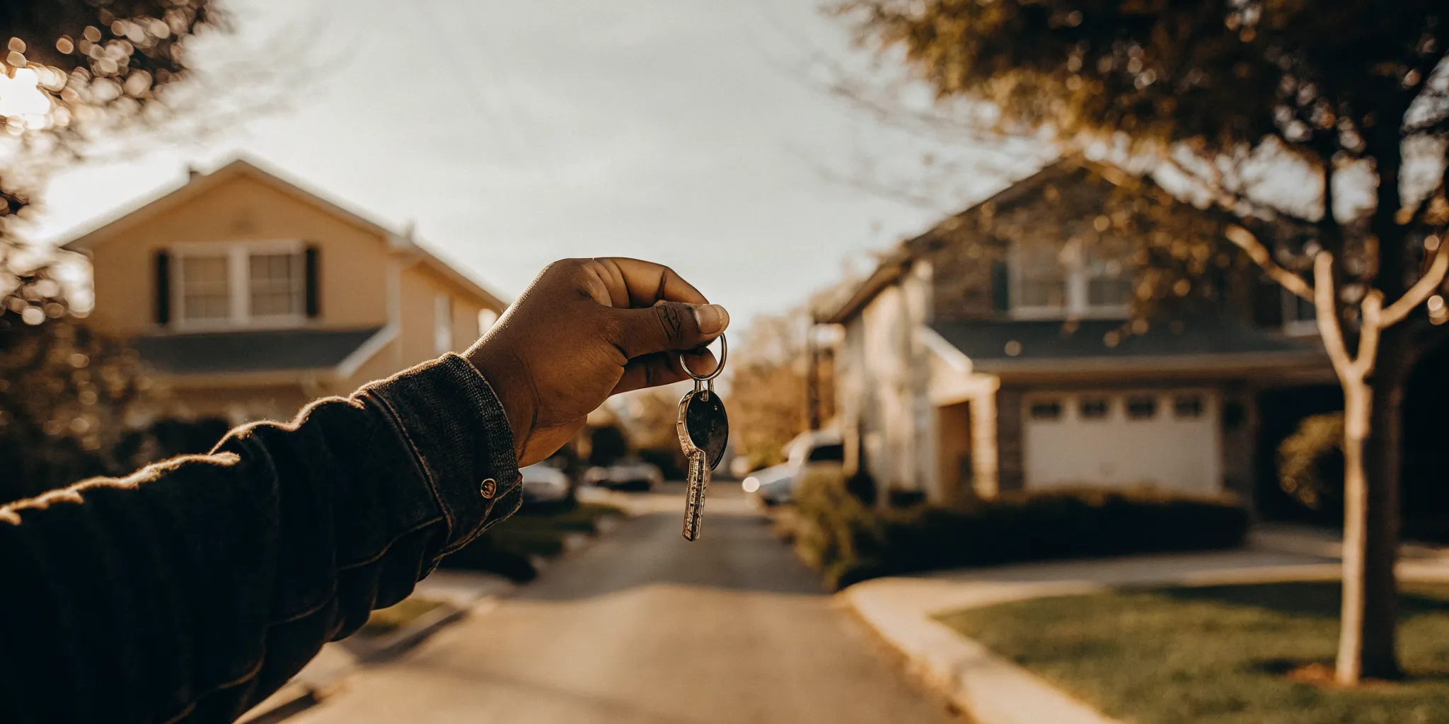 New Texas homebuyer holding house keys in front of suburban home, first time buyer